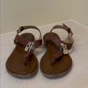 Women’s Brown Michael Kors Sandals with Charm Accents. Adjustable side buckle.